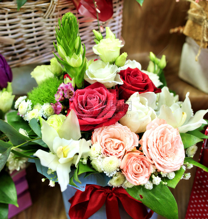 一束美丽的鲜红粉和白玫瑰在柳条篮上绽放的特写盛开一种浪漫的图片