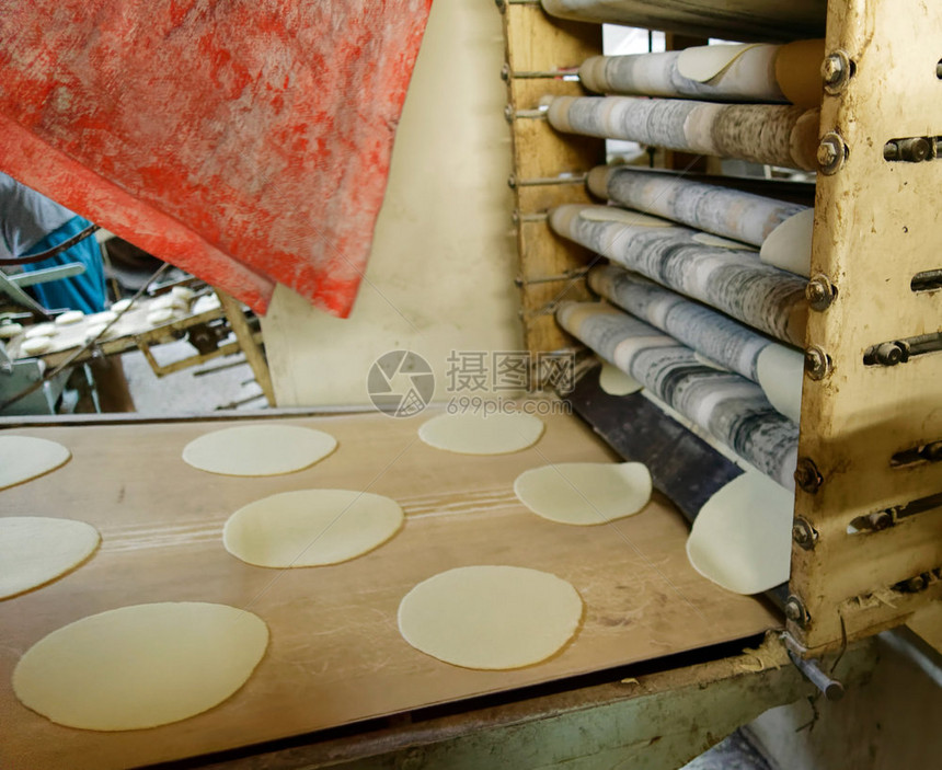 在约旦中东部阿卡巴最大的面包店自动生产阿拉伯扁面包的老旧机约旦阿卡巴扇子机器赤叶图片