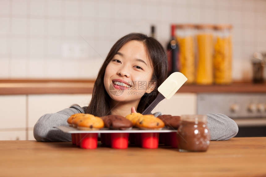 在厨房里微笑着的亚洲女人照片盘子里装满了松饼只要诱惑腰部图片