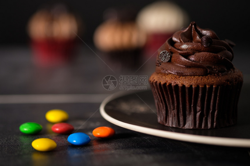 棕色的撒模糊巧克力蛋糕在陶瓷盘上黑暗灯光下AF点选择图片
