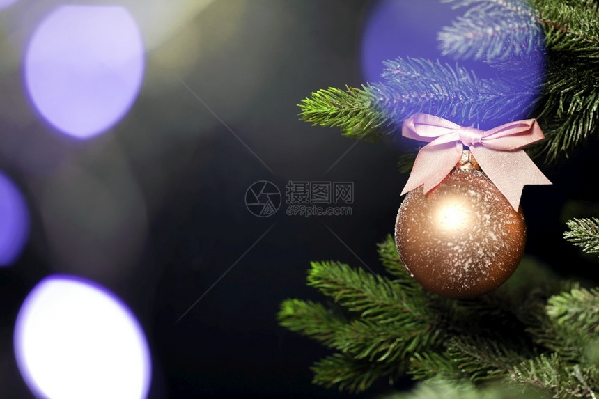 季节一个单独的圣诞摆设挂在树的新鲜绿色枝上靠近深黑色背景带有复制空间圣诞快乐文本的假日概念空间一个单独的圣诞摆设在树的新鲜绿色枝图片