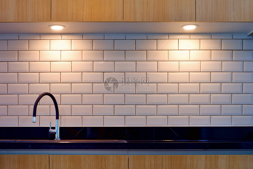 现代水龙头和黑棒下沉的色条纹前方白砖墙壁表面照明现代厨房风格的木制顶楼最小电灯泡光图片