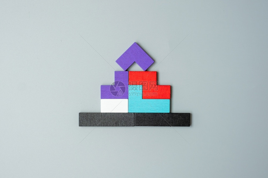 在灰色背景逻辑思维商业解决方案理住房地产和战略概念上以多彩的木质拼图块构成的家庭形状块情商建造完全的图片