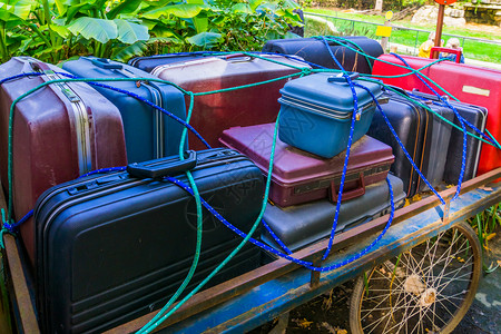 装满手提箱的旧式行李车用绳子怀旧行李运输方式固定行李箱处理不同的大车图片