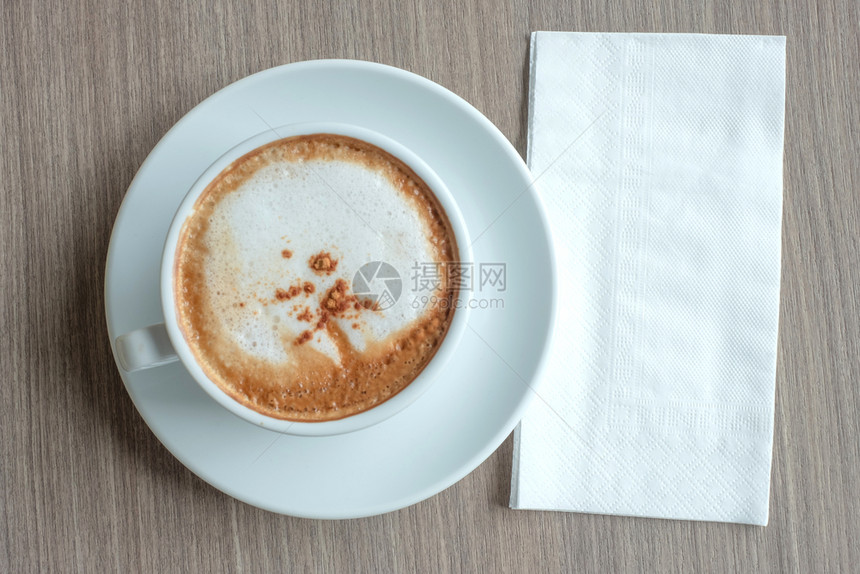 黑暗的笔记本早上xt时餐桌背景上加热卡布奇诺咖啡杯的文字白纸床单图片