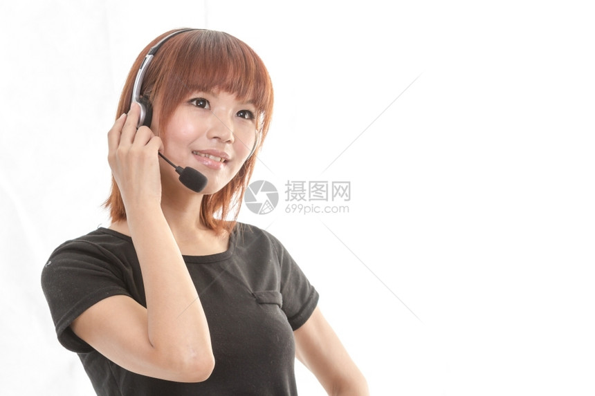 微笑漂亮的亚裔女佩戴耳机麦克风商业图片