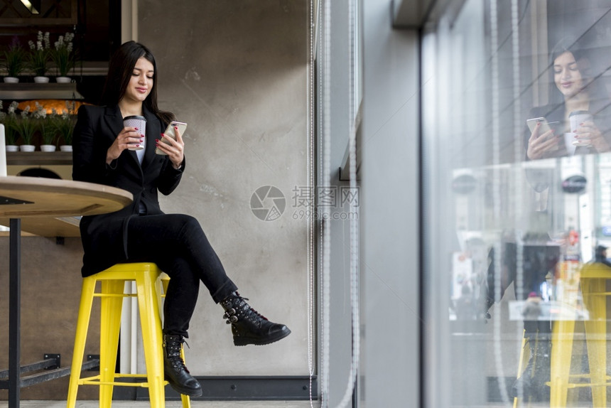 在室内时髦的使用智能手机黑褐色女商人办公室图片