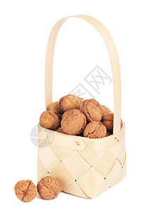 晒干麻辣烫木制篮子中的胡桃在Wooden篮子里的白色背景上被孤立胖的图片