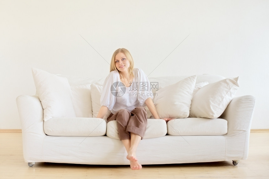 可爱的年轻女孩在家里沙发上放松感的水平成人图片
