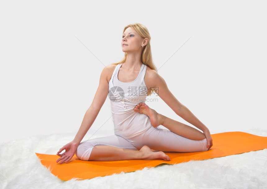 年轻漂亮女孩在专业上从事瑜伽工作摆姿势人们在室内图片