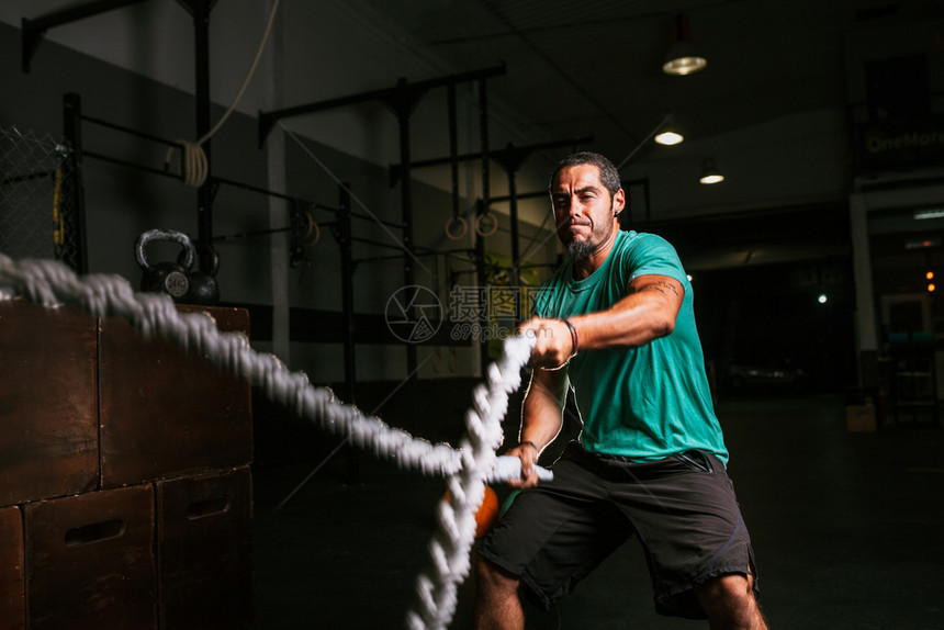 健身房绳索锻炼的成年男子图片