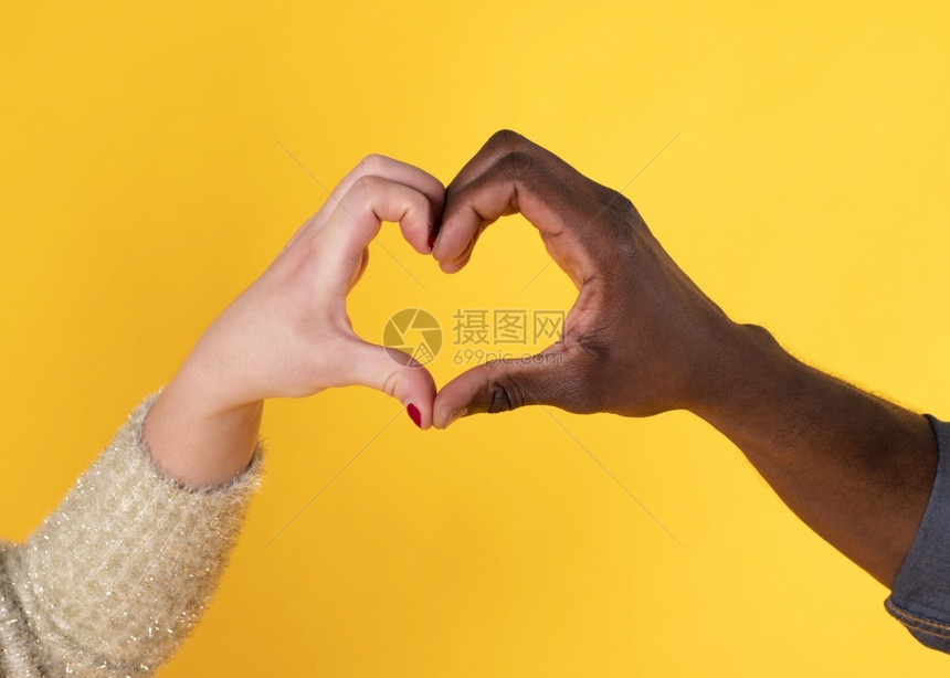 成人红心手形状黑和白跨种族黄色背景多民族女图片