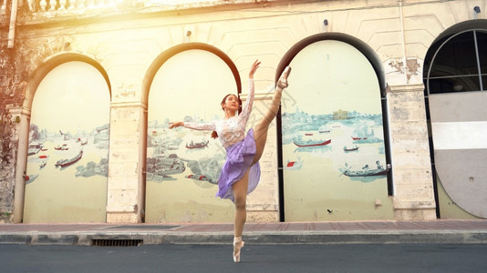 沿着在泰国曼谷街上跳舞的年轻美丽芭蕾舞女郎年轻的图片