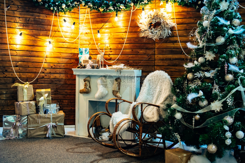 带有温暖灯光木制元素和礼物的罗马古典圣诞节内室木制的头家图片
