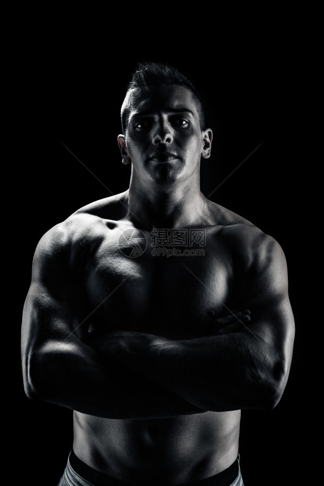 运动吸引人的胸饰黑色背景上交叉手的健修者低光肖像图片