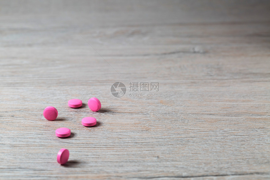 粉红色圆丸堆积在光辉桌边粉红色圆丸堆积在明亮背景上自己桌子胶囊图片
