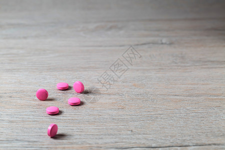 粉红色圆丸堆积在光辉桌边粉红色圆丸堆积在明亮背景上自己桌子胶囊图片