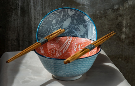 两个陶瓷碗粉桌布上有木筷子的陶瓷餐具美丽安排选择焦点美丽的水泥细节图片