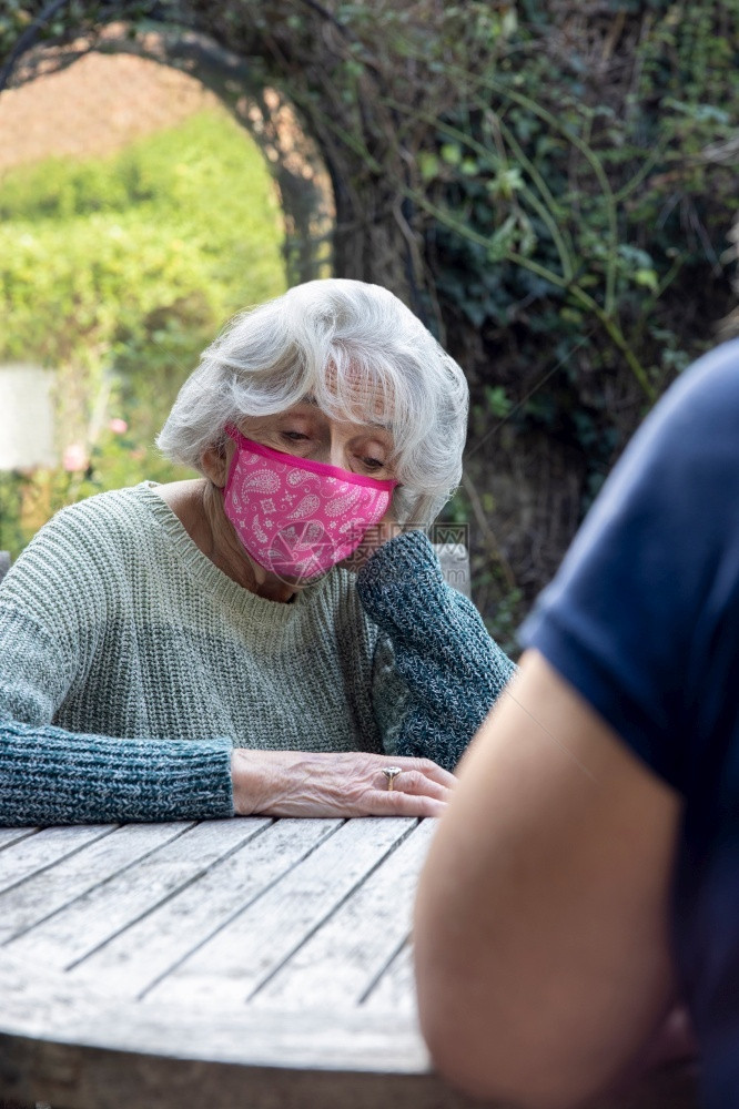 禁闭期间有一位身着面具的女士在花园里单身受压抑的年老母亲来访成熟父母精神的图片