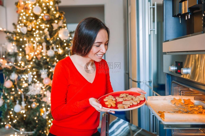 白种人面糊粉快乐的年轻家庭主妇在圣诞节做姜饼干在家里做圣诞曲奇在家做圣诞帽子烤姜饼的年轻女人图片