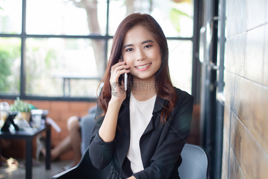 自信的女使用电话在移动上进行手机接听和发短信的女商人业图片