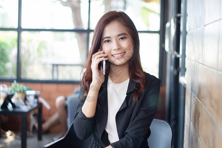 自信的女使用电话在移动上进行手机接听和发短信的女商人业图片