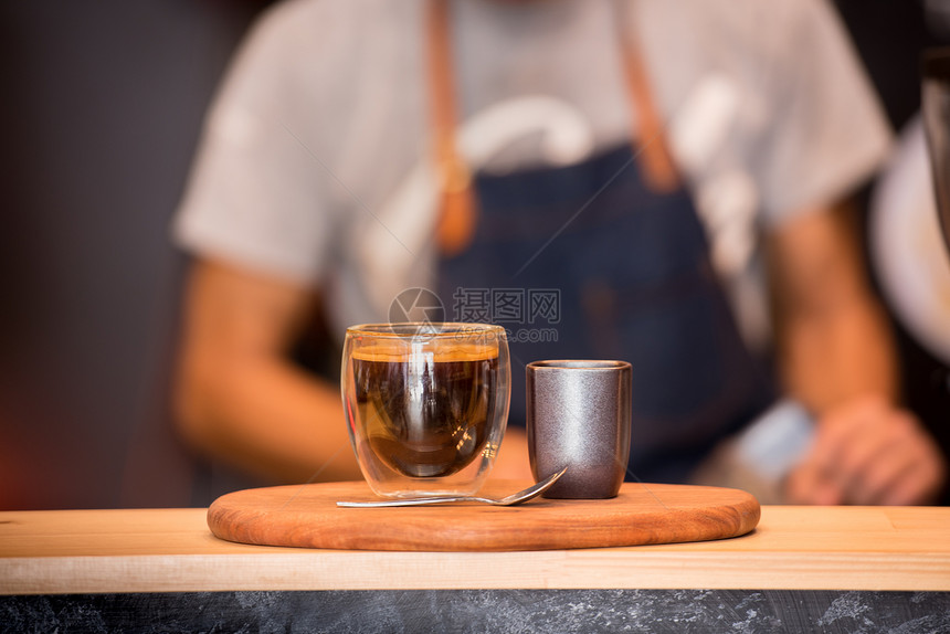 木桌上的黑咖啡杯和露面水平泡沫背景效应Wooden桌上的黑咖啡杯液体制造象征图片