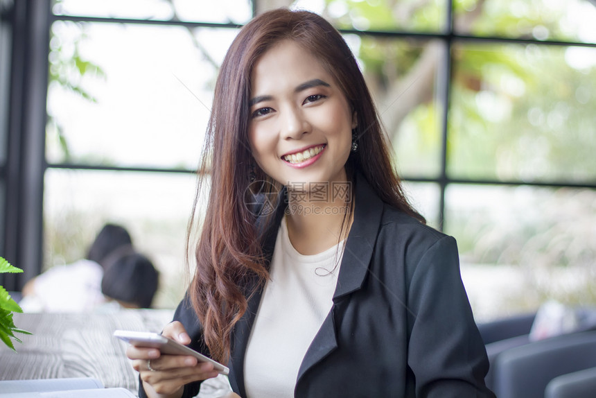 办公室使用笔记本和智能电话的亚洲商业妇女以及笑着快乐工作的女商业妇秘书成人图片