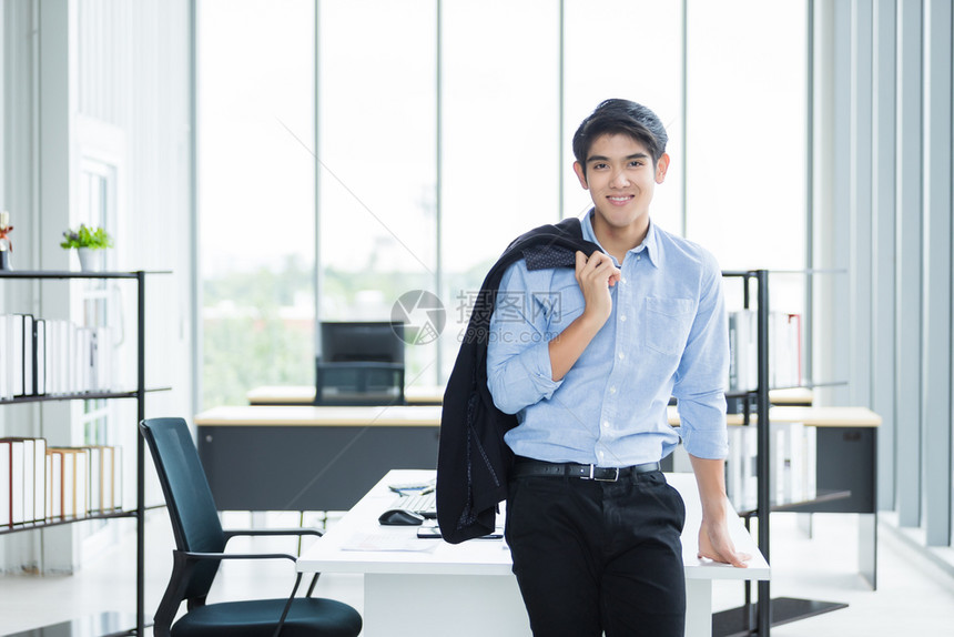 单身的常设成功办公室背景中一位快乐的成熟商人肖像在办公室背景中图片