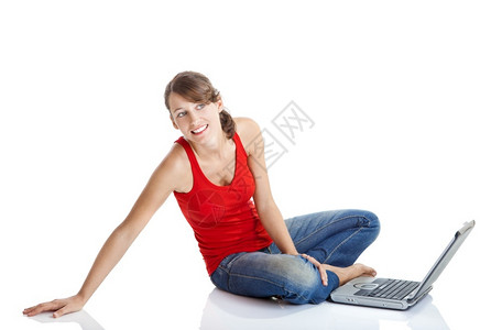 白种人坦率坐在地板上用笔记本电脑工作的美丽年轻女士感图片