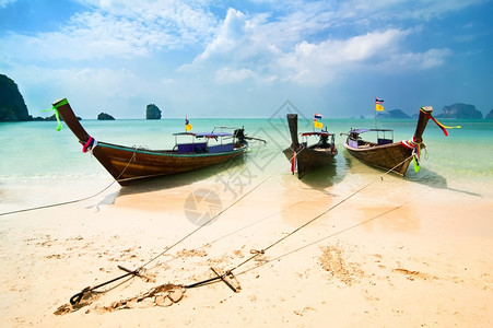 船钩航运甲米云泰国传统的长尾船位于泰国拉莱克比维亚蓝天普南洞穴海滩下的洋湾背景