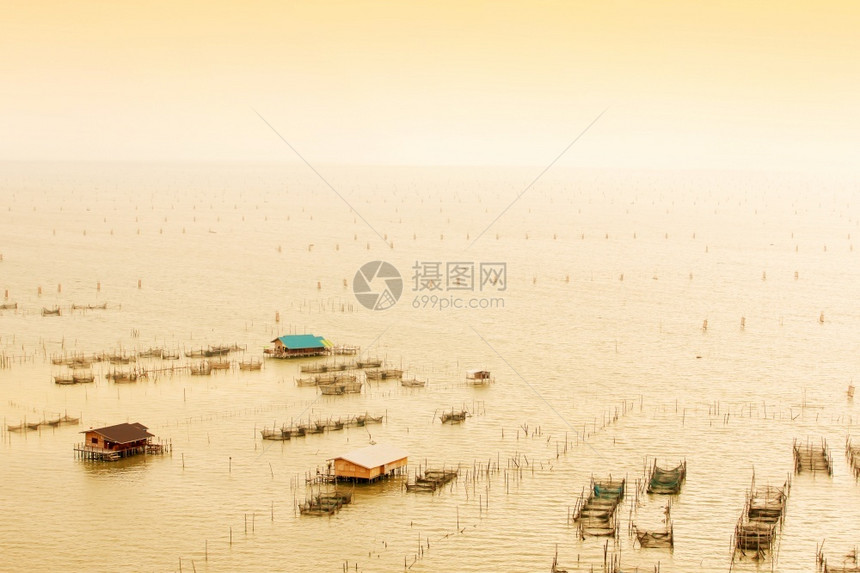 淡水农民在泰国自然湖Songkhla湖黄昏时从空中查看豪船群和许多传统鱼捕渔网日落图片