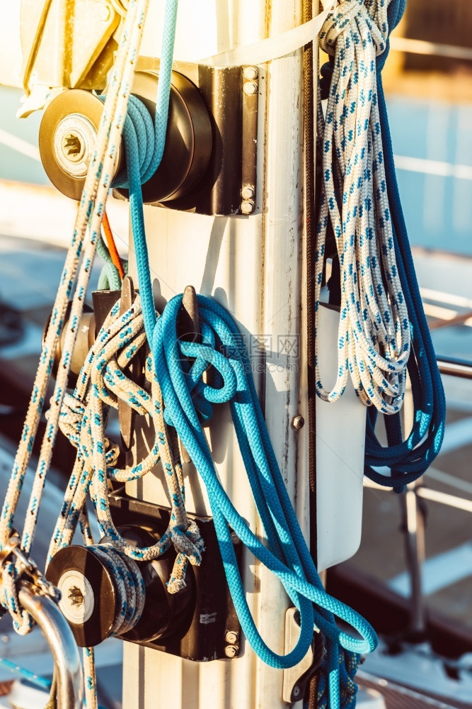 扭曲的带绳子和其他设备的娱乐游艇细节有绳子和其他设备擦透了背面太阳反射的镜头过滤假期图片