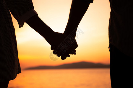 季节浪漫旅行夏日在海滩落时情侣握手牵图片