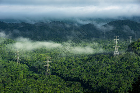 高压电源输塔在山上MameMohmoh灯阳雾中电输送塔白色的绿力量图片