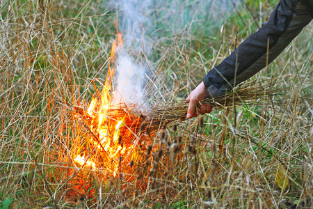 男人安全遗迹用干草点燃火图片