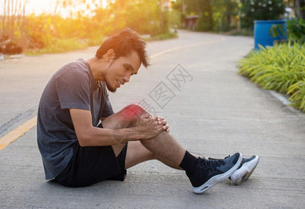 男子跑者在早晨慢运动但步时意外腿痛体育与健康抓住髌骨事故图片