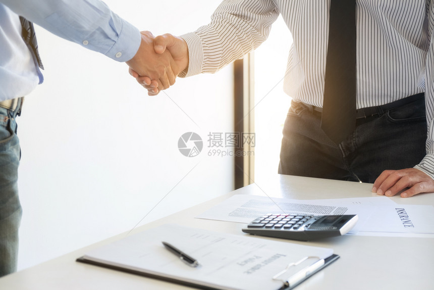 为了与客户握手以便成功处理合同协议中的交易为合同协议中的成功交易而与客户握手投资高管图片