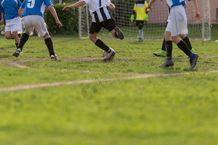 团队享受优胜者比赛中的小足球选手收紧儿科人腿图片