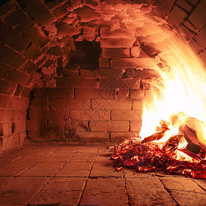 火柴燃烧在一个老烤炉中准备做饭生锈的橙烤箱图片