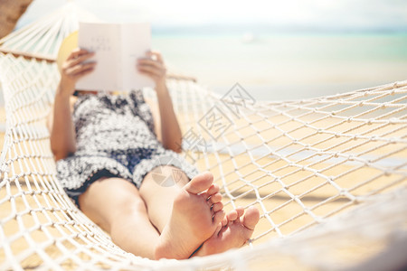 夏天女在节假日暑自由时间阅读关于吊床上海滩的书籍旅游躺着图片