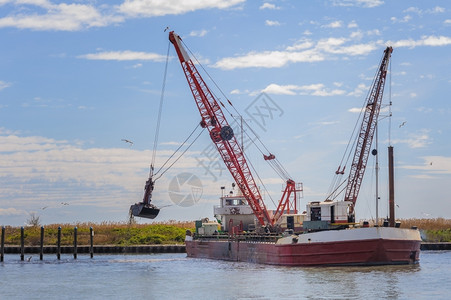 疏通加载货物小型挖掘船坞该码头正在清理一个航道图片