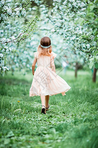 复活节时尚花春日盛开的苹果园里可爱小女孩B春日盛开的苹果树园里可爱小女孩背景图片