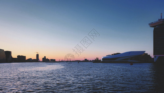 区塔黄昏时河水淹没了日落时的阿姆斯特丹港和马欧洲的图片