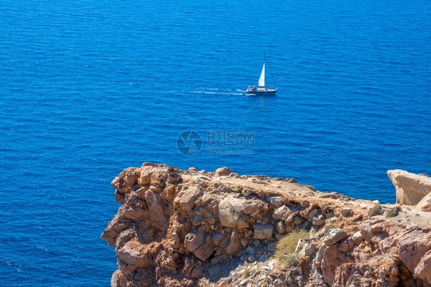 旅游岩石海岸上的阳光天气石灰岩悬崖蓝海中的孤独帆船蓝海中的石灰岩和帆船岛蓝色的图片