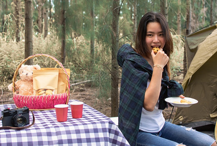 野餐亚洲美丽的女在夏日露营时吃零食的亚裔美女旅行和背包机概念游客女孩图片