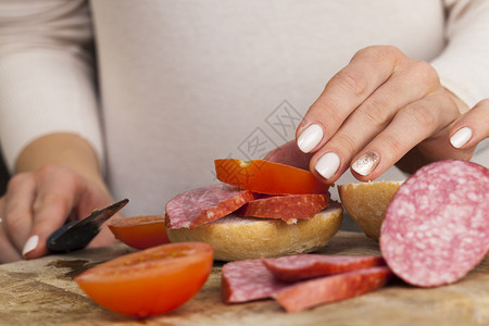 早餐东欧在家准备三明治时将香肠和西红柿切成肉卷和番茄并配面包火腿猪肉图片