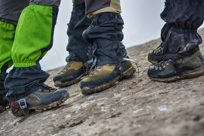 污垢游客双脚穿戴带石的远足鞋在背景中的侧面观旅游概念路图片