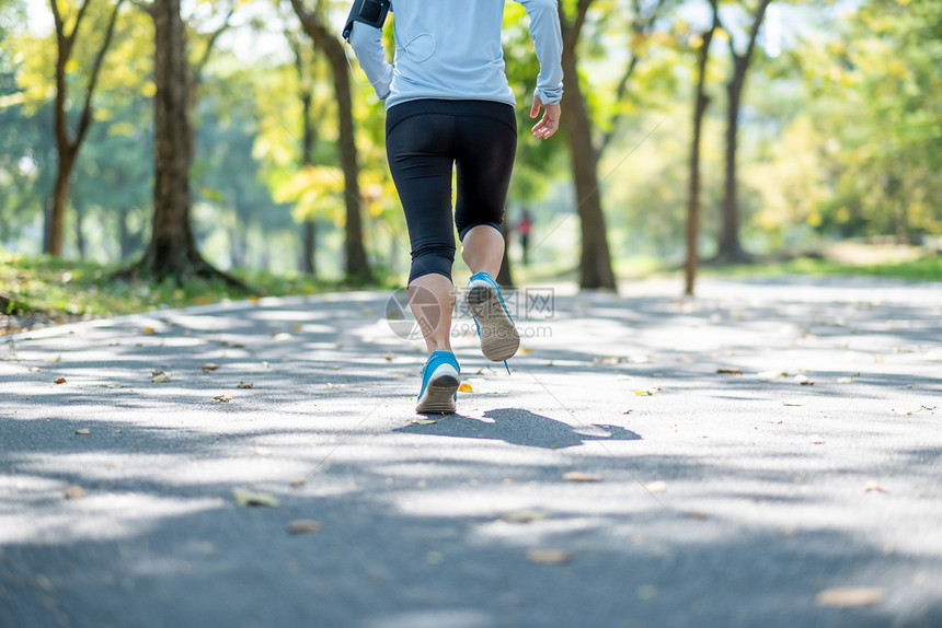 步行女年轻的健身腿在户外公园散步女跑者在外面的路上跑步亚洲运动员在阳光下人行道上慢跑和锻炼运动健康和保概念水图片