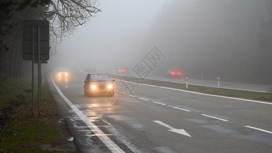 寒冷的恶劣天气驾驶浓雾Hazy乡间公路高速交通湿的白色图片